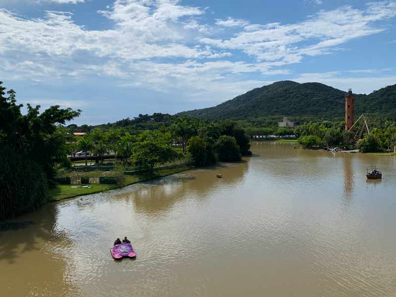 Pessoas andam de pedalinho no Beto Carrero em dia de céu com algumas nuvens