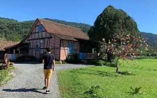 Homem caminha em frente à casa de estilo enxaimel em Pomerode, SC