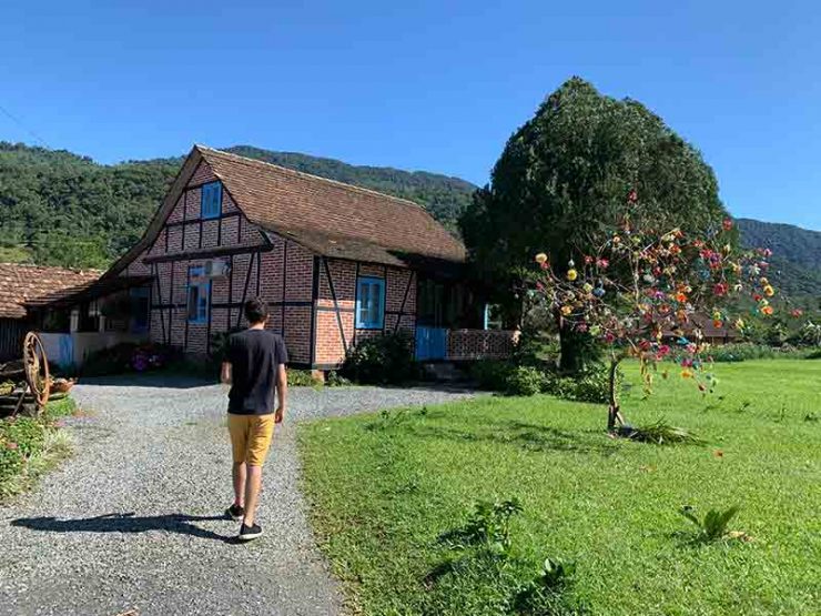 Homem caminha em frente à casa de estilo enxaimel em Pomerode, SC