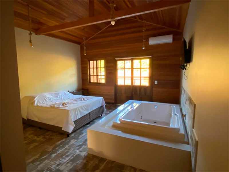 Quarto da Recanto Pomerano, uma das pousadas em Pomerode, com cama de casal, banheira de hidromassagem e ar-condicionado