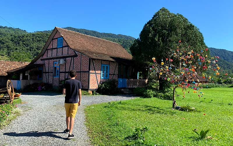 O que fazer em Pomerode: Homem caminha em meio a um jardim em casa na Rota do Enxaimel