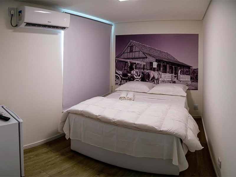 Quarto da Suítes Containers com foto na parede e cama de casal