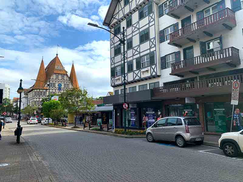 Rua XV de Novembro, em Blumenau, com construções em estilo enxaimel em dia de céu azul com nuvens