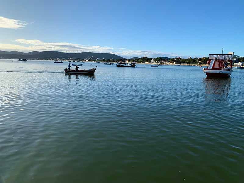 Vista do mar com barcos a partir do Bar Flutuante Porto do Sol