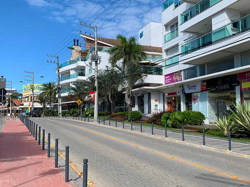 Uma das principais avenidas do centro de Bombinhas vazia em dia de céu azul