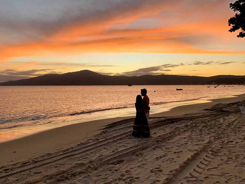 Casal aprecia o pôr do sol na Praia do Canto Grande - Mar de Dentro