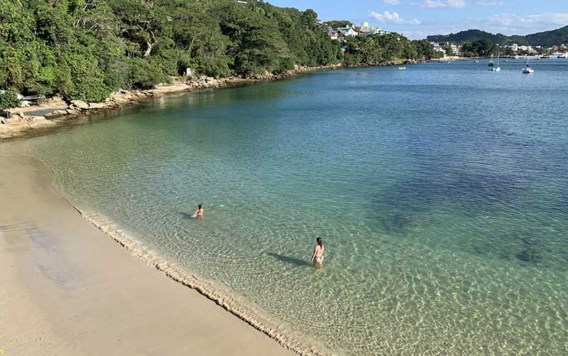 Vista aérea da praia com duas garotas na água em Bombinhas, SC