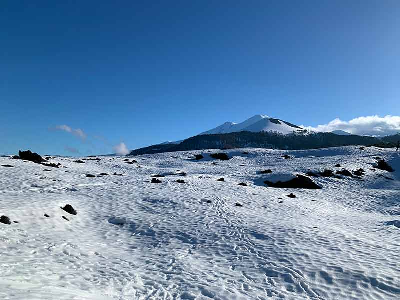 Neve e vulcão em dia de céu azul no Parque Nacional Conguillio