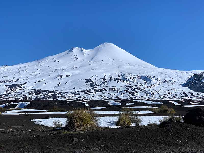 Vulcão Llaima com muita neve em dia de céu azul em Conguillio, na região da Araucanía, no Chile