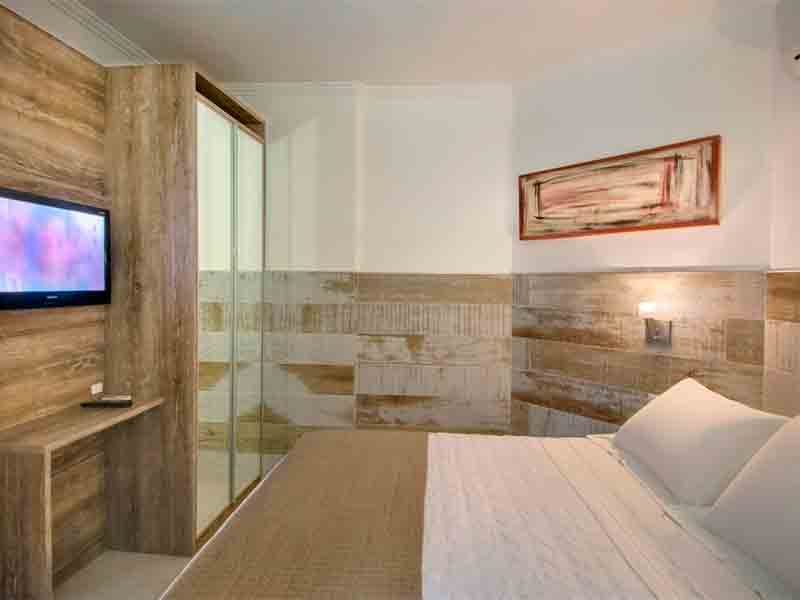 Quarto da Pousada Bora Bora com cama de casal, TV e guarda-roupa