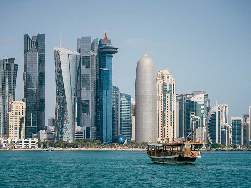 Vista dos prédios em Doha com tradicional barco qatari