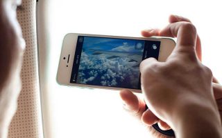 Chip de celular para o Qatar: Pessoa segura celular e grava paisagem pela janela do avião