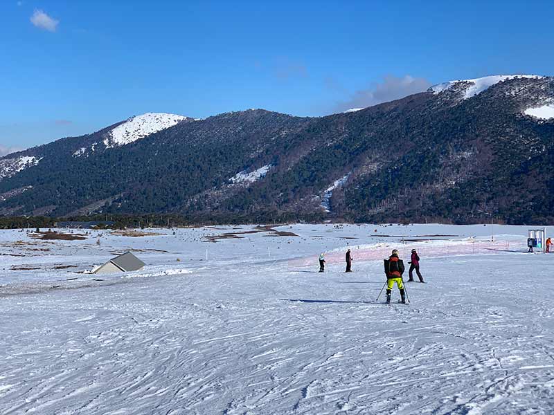 Pessoas esquiam em Corralco, no Chile, em dia de céu azul