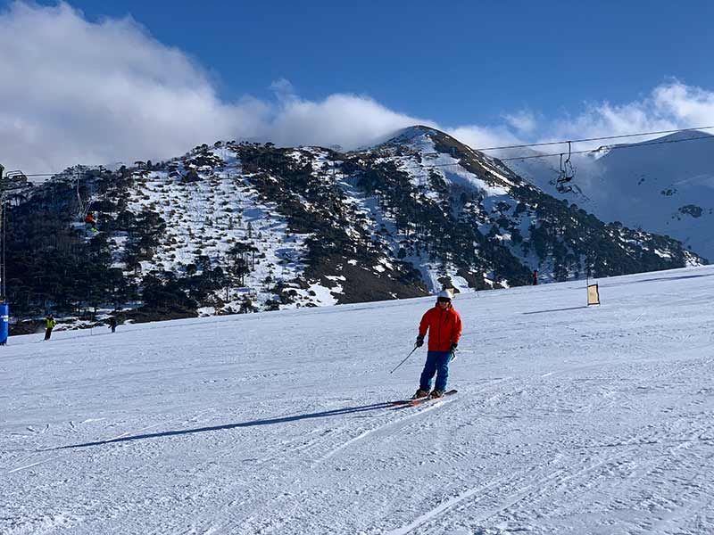 Pessoa esquia em Corralco perto de montanhas com neve na região da Araucanía, no Chile