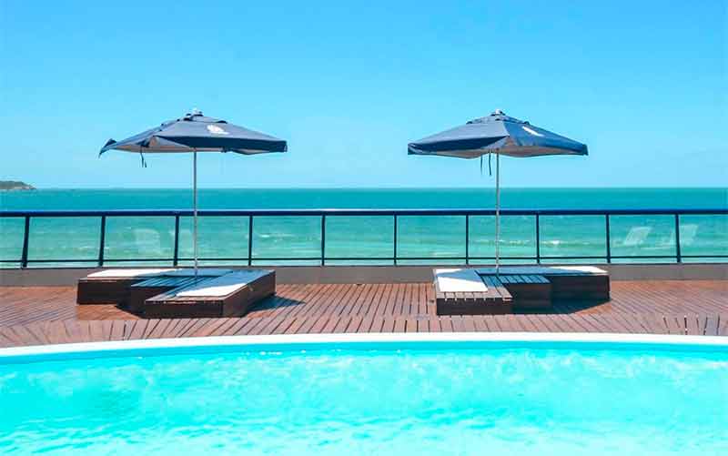 Piscina da Garatéia, dica entre as pousadas em Bombinhas, com guarda-sóis em frente à praia