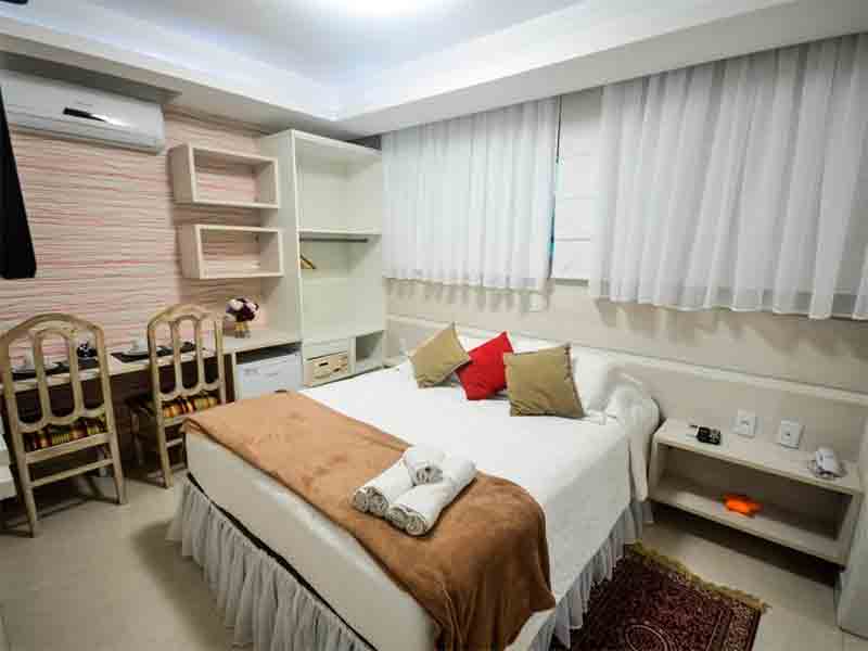 Quarto da Retiro das Ilhas, uma das pousadas em Bombinhas, com cama de casal e TV