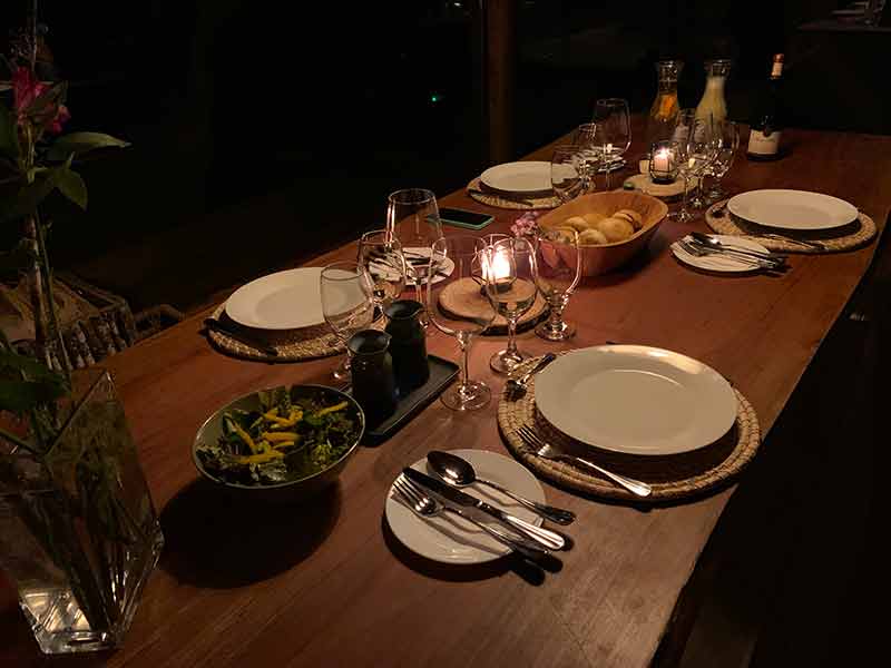 Mesa do jantar no Samadhi com salada, pães e vinho