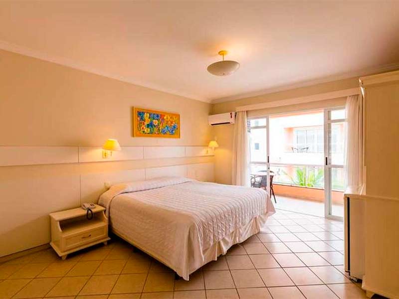 Quarto do Vila do Coral com cama de casal, quadro, ar-condicionado e varanda
