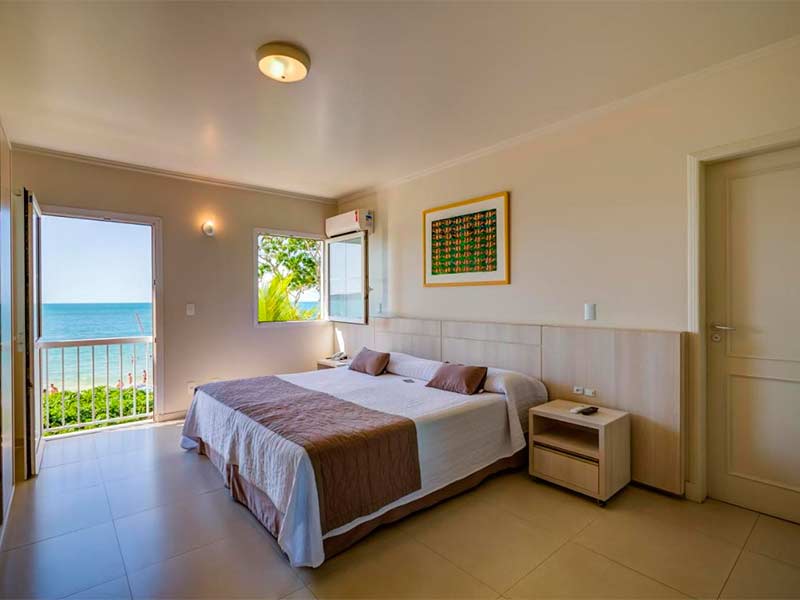 Quarto do Vila do Farol com cama de casal e vista para a praia de Bombinhas