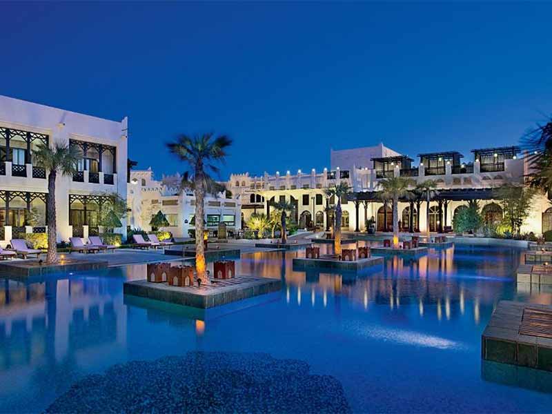 Piscina ao anoitecer do The Ritz-Carlton Sharq Village, opção de hotel no aeroporto de Doha