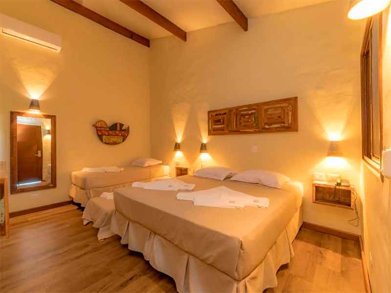 Quarto do Bonito Ecotel, dica entre os hotéis em Bonito, com cama de casal e de solteiro e decoração clean