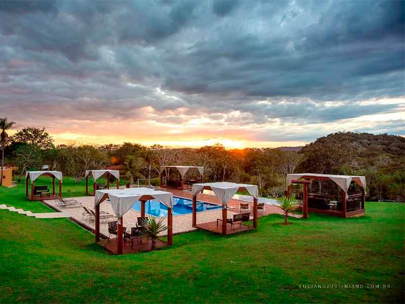 Área da piscina da Boyrá com cabanas no fim de tarde