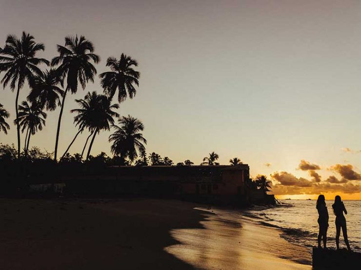 Pôr do sol na praia com silhueta de duas pessoas - como ir para Maragogi