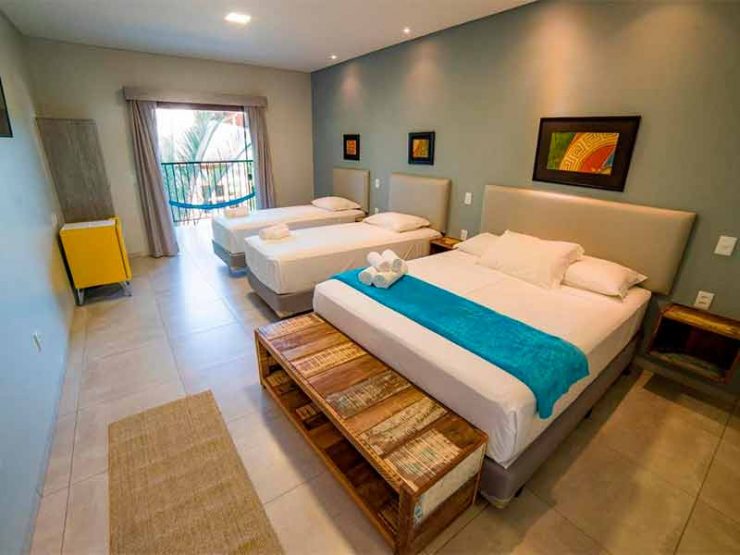 Quarto da Girassol, dica entre os hotéis em Bonito, com cama de casal e duas de solteiro e frigobar amarelo