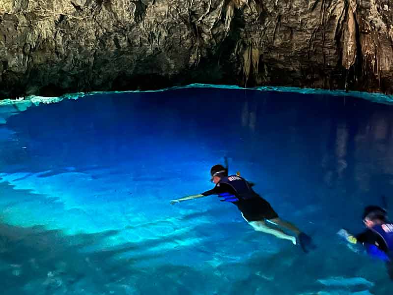 Homem faz flutuação em Bonito nas águas claras da Gruta do Mimoso