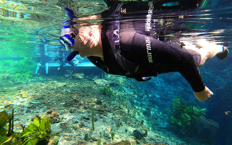 Homem faz flutuação em Bonito nas águas claras da Nascente Azul