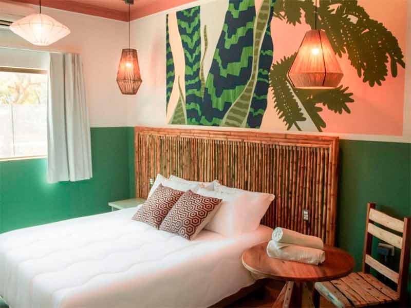 Quarto do Selina com cama de casal e decoração em tons de verde