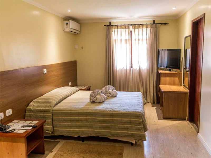 Quarto do Zagaia Resort com cama de casal e TV