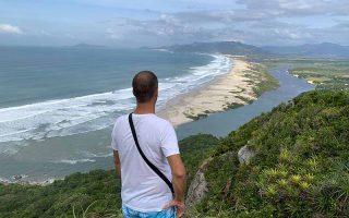 Homem vê a Guarda do Embaú do alto da Pedra do Urubu