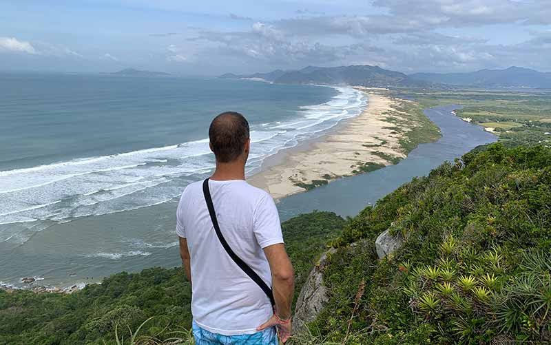 Homem vê a Guarda do Embaú do alto da Pedra do Urubu