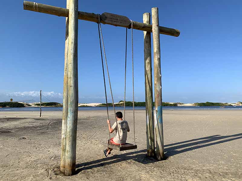 Homem em balanço na praia da Guarda do Embaú
