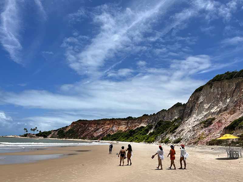 Pessoas em frente a falésias na Praia de Tabatinga, na Paraíba