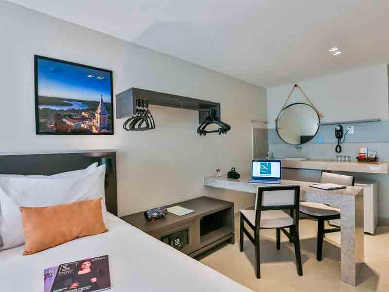 Quarto do Quality Suítes, dica de hotel em João Pessoa, com cama e mesa de trabalho