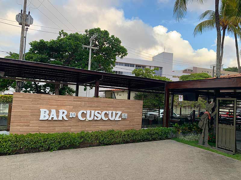 Entrada do Bar do Cuscuz, dica do que fazer em João Pessoa, em dia de céu azul com nuvens