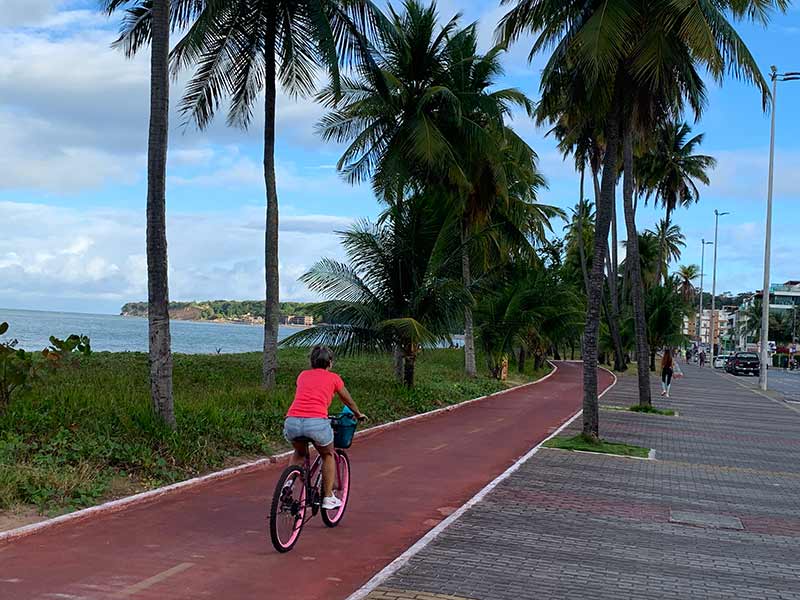 Mulher anda de bicicleta pela orla de Cabo Branco