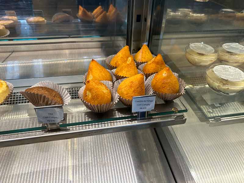 Coxinha de frango e quibe expostos em vitrine