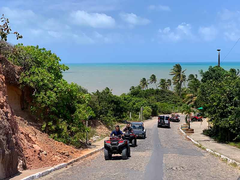 Descida para a praia de Coqueirinho, dica do que fazer em João Pessoa, com buggy na estrada,  mar e coqueiros