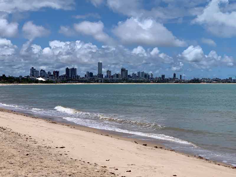 Prédios ao fundo, mar e areia vazia de Manaíra, uma das praias de João Pessoa