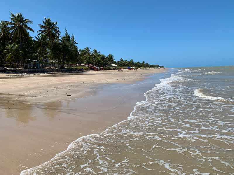 Mar e areia vazios em dia de céu azul na Praia do Poço, em Cabedelo