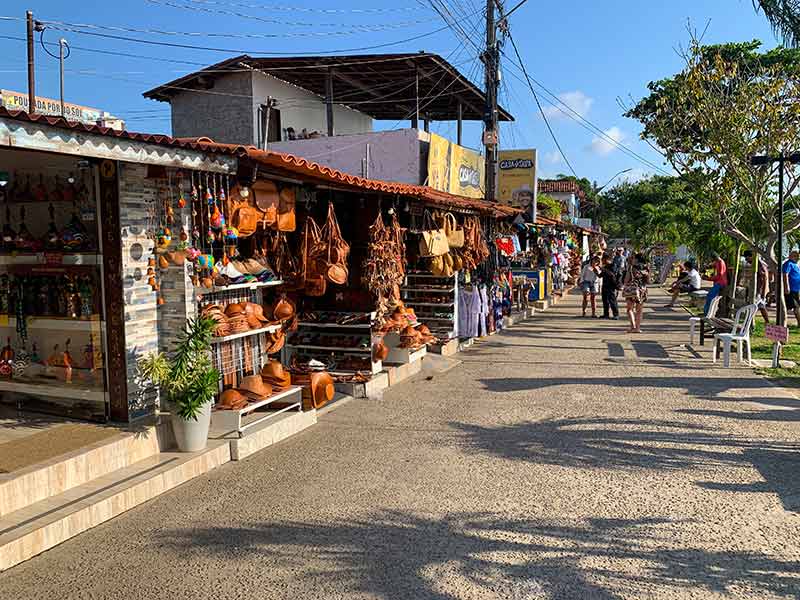 Orla da praia pouco antes do pôr do sol do Jacaré com lojinhas e pessoas passeando