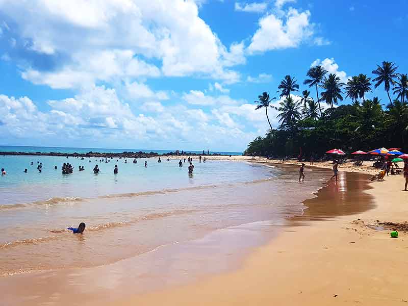 Pessoas curtem o mar e aproveitam a areia na Praia de Coqueirinho, perto de João Pessoa