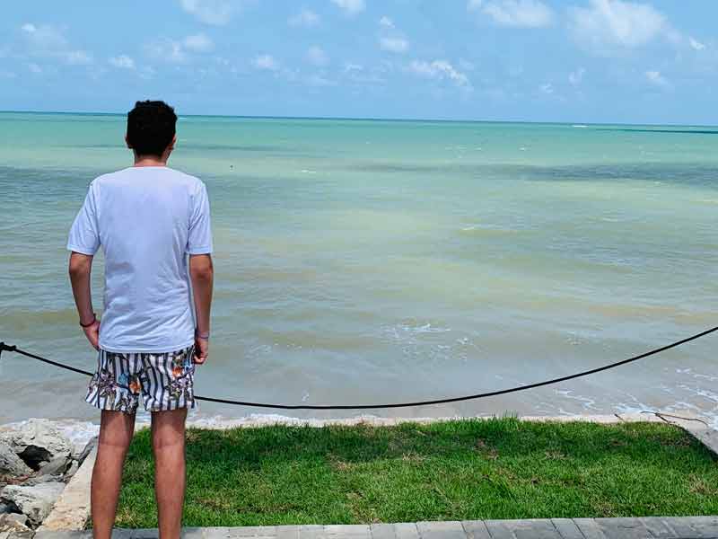Homem em pé observa o mar no Lovina da Ponta do Seixas