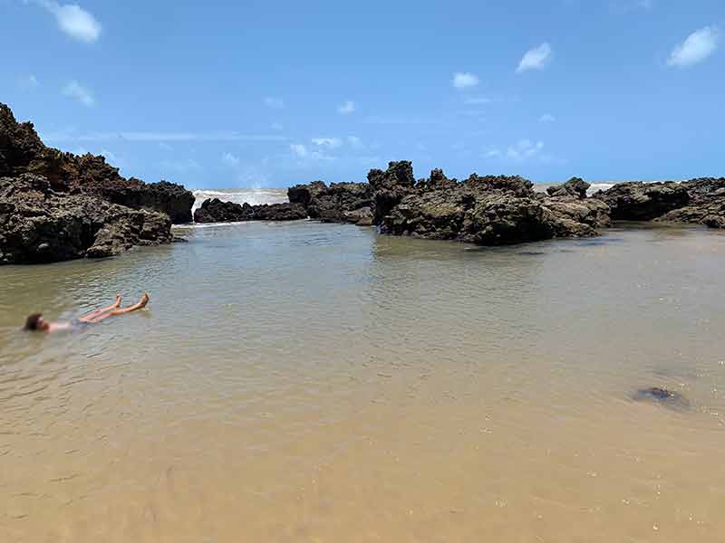 Pessoa boia em piscina natural em Tambaba