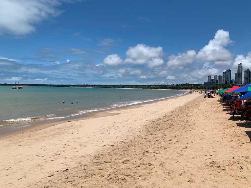 Praia de Tambaú, dica de o que fazer em João Pessoa, em dia de céu azul e guarda-sóis na areia