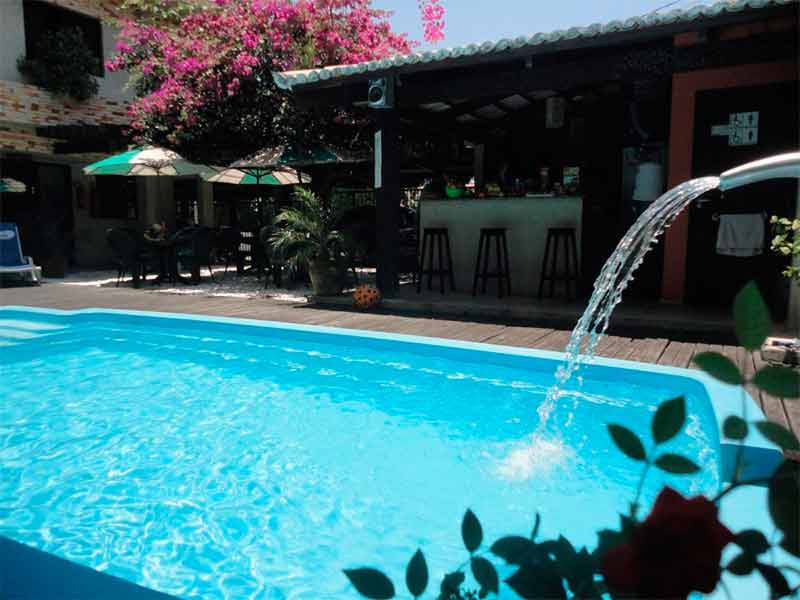 Piscina com cascata da Beija-flor, pousada em Natal, com bar à frente