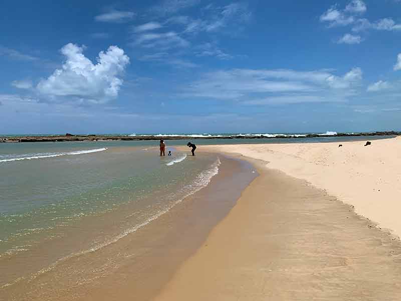 Pessoas se divertem no mar vazio de Camurupim, no Rio Grande do Norte